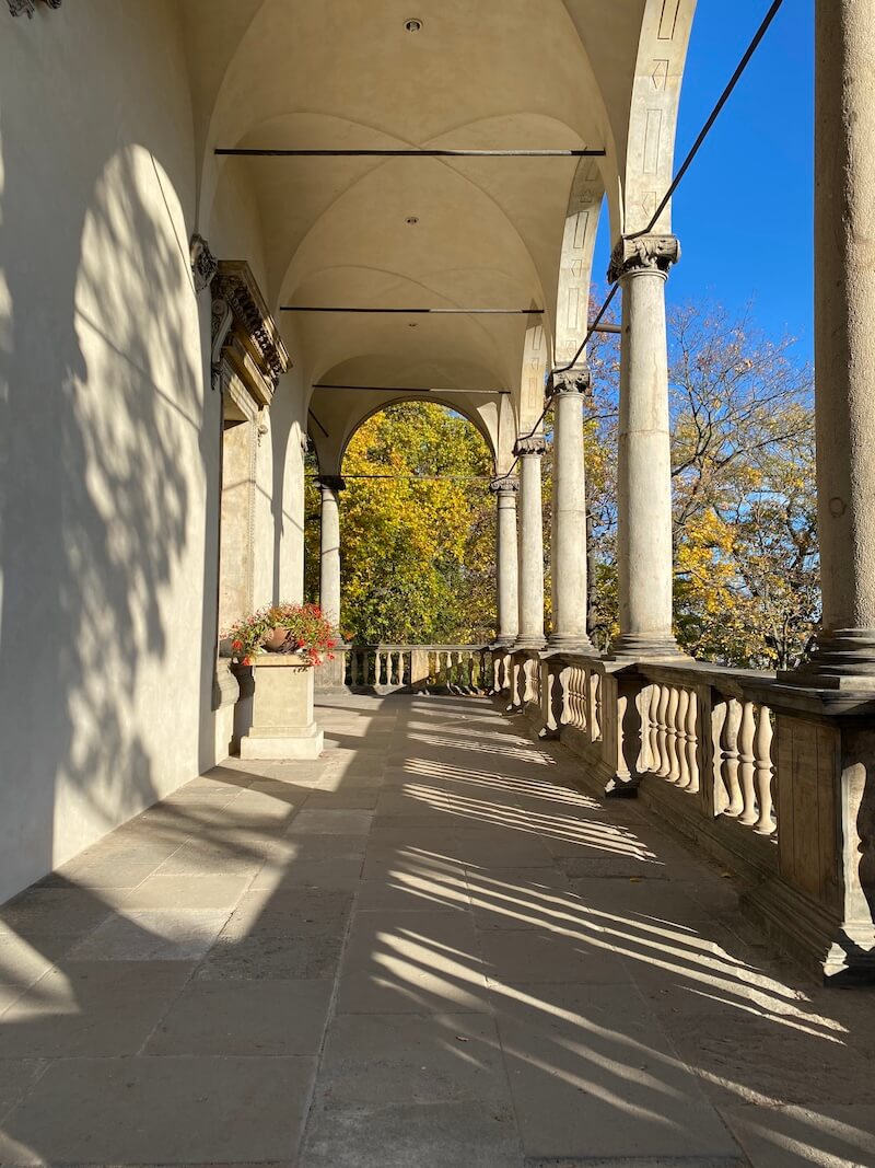 Anne and Ferdinand actually shared a notably respectful marriage, which wasn’t all that common among royal couples of the time. The palace he commissioned may have started as a romantic gesture and, after her death, became something more personal. The building later served a range of purposes: royal gatherings, scientific experiments, and even artillery storage. Today, it’s known for its elegant symmetry, arcaded gallery, and beautiful sgraffito decoration—though the original furnishings and interiors have long been lost to history. Queen Anne’s Summer Palace is a bit of a mouthful. And the Czech name, Královský letohrádek, doesn’t exactly roll off the tongue either. But I like the alternative that you may hear: Belvedere. It's a name borrowed from Italian that means “beautiful view.” This actually describes the scene much better. The Belvedere simply looks different from the other buildings around the Castle. With clean lines, arched columns, and a distinctive copper roof, it remains a symbol of Renaissance elegance and one of the earliest signs of Italian influence in Bohemia side colonnade Anne and Ferdinand actually shared a notably respectful marriage, which wasn’t all that common among royal couples of the time. The palace he commissioned may have started as a romantic gesture and, after her death, became something more personal. The building later served a range of purposes: royal gatherings, scientific experiments, and even artillery storage. Today, it’s known for its elegant symmetry, arcaded gallery, and beautiful sgraffito decoration—though the original furnishings and interiors have long been lost to history. Queen Anne’s Summer Palace is a bit of a mouthful. And the Czech name, Královský letohrádek, doesn’t exactly roll off the tongue either. But I like the alternative that you may hear: Belvedere. It's a name borrowed from Italian that means “beautiful view.” This actually describes the scene much better. The Belvedere simply looks different from the other buildings around the Castle. With clean lines, arched columns, and a distinctive copper roof, it remains a symbol of Renaissance elegance and one of the earliest signs of Italian influence in Bohemia side colonnade